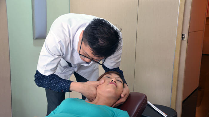Doctor providing patient accident or sports injury chiropractic treatment